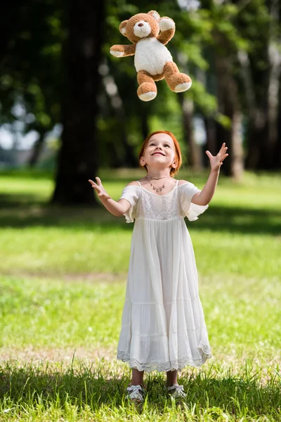 Girl with teddy bear in park — Stock Photo, Image