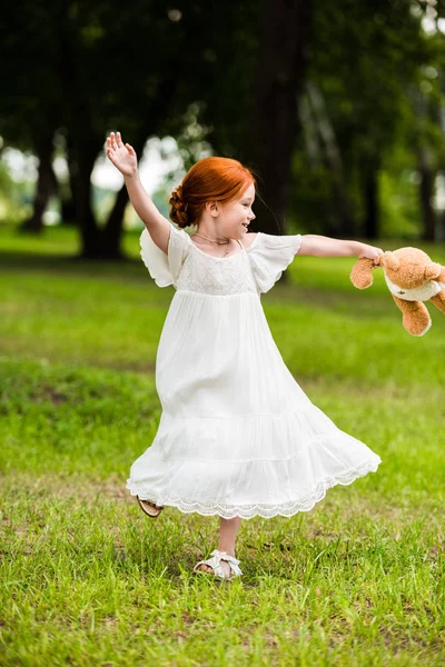 Girl with teddy bear in park — Stock Photo, Image