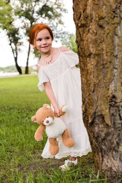 girl with teddy bear in park