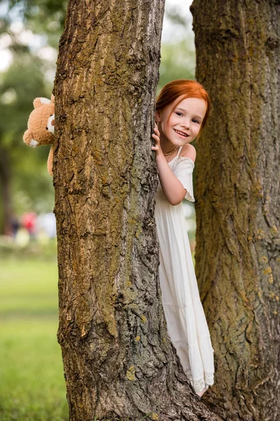 Chica con osito de peluche en el parque — Foto de Stock