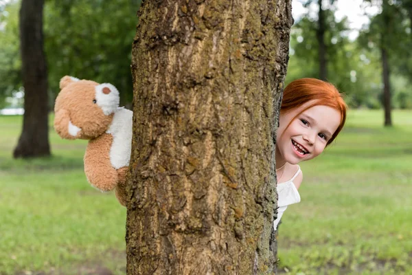 Girl with teddy bear in park — Stock Photo, Image