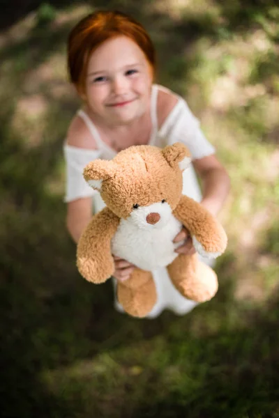 Menina com ursinho de pelúcia no parque — Fotografia de Stock