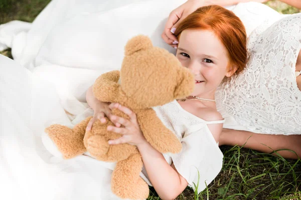 Mother and daughter with teddy bear in park — Stock Photo, Image