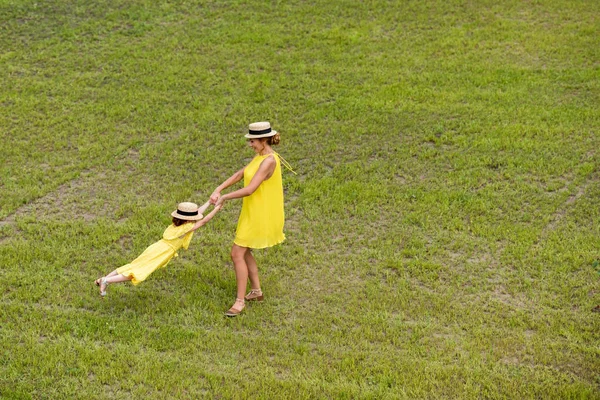 Mother and daughter walking on lawn — Free Stock Photo