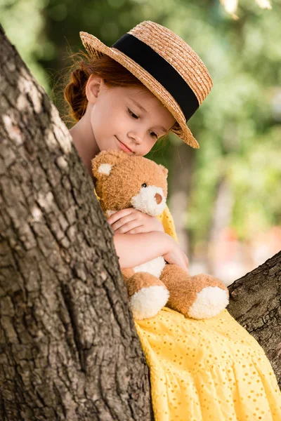 Girl with teddy bear on tree — Stock Photo, Image