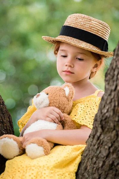 Dívka s plyšovým medvědem na stromě — Stock fotografie