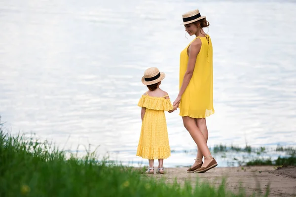 Mutter und Tochter gehen am Flussufer spazieren — Stockfoto