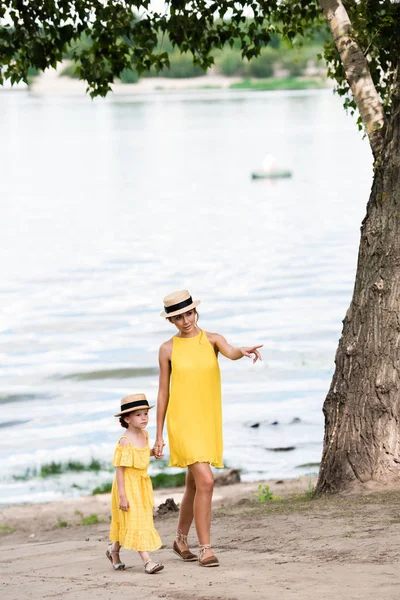 Mãe e filha andando à beira do rio — Fotografia de Stock