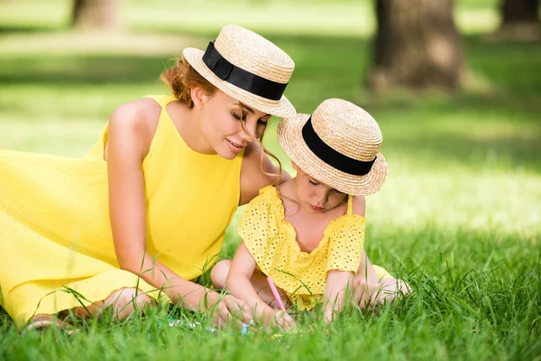 Mother and daughter drawing in park — Free Stock Photo