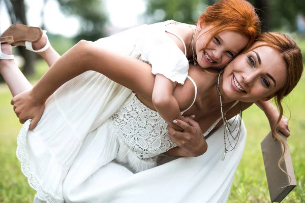 Mãe piggybacking filha no parque — Fotografia de Stock