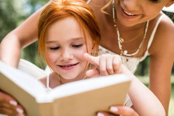 Mother and daughter reading book Stock Picture