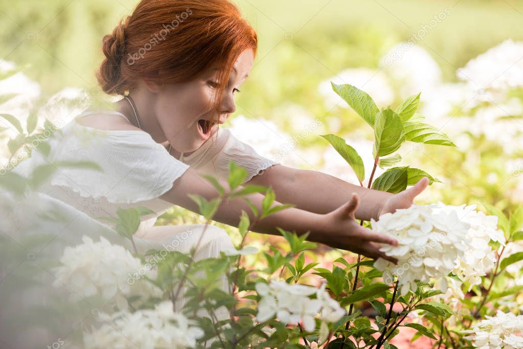 redhead girl in flower bed