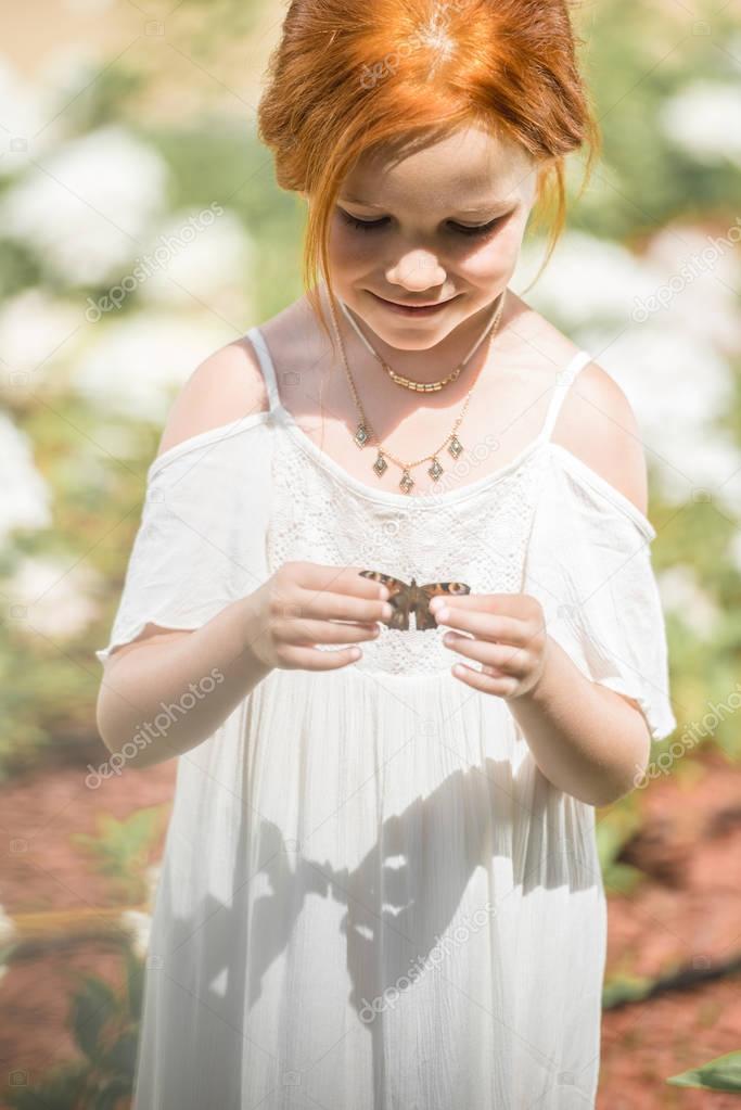 little girl holding butterfly