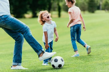 father with kids playing soccer clipart