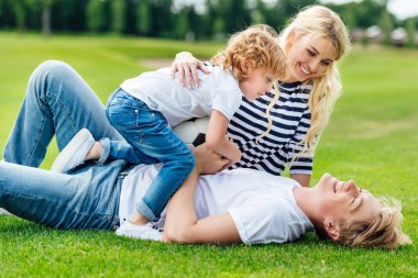 parkta oynarken futbol topu ile aile