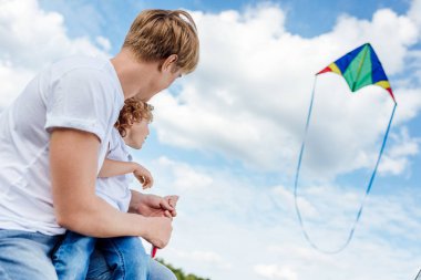 father and son playing with kite clipart