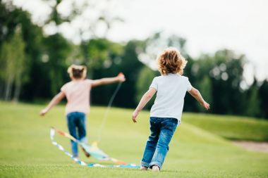 siblings playing with kite clipart