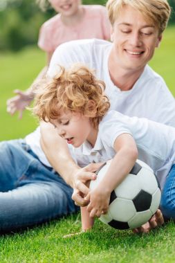 Baba ve oğul parkta futbol oynamak