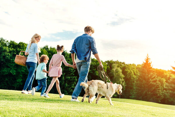 family with dog walking at park 