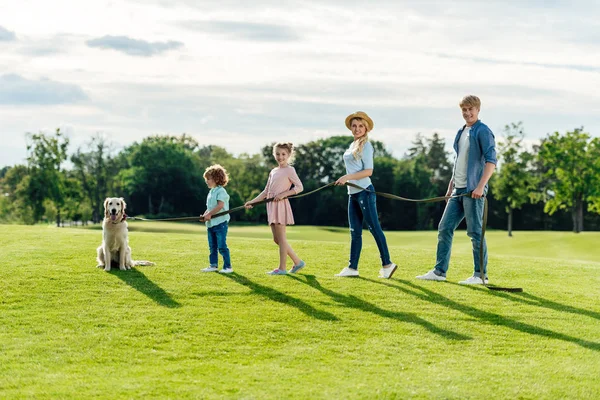 Familj med hund promenader på park — Stockfoto