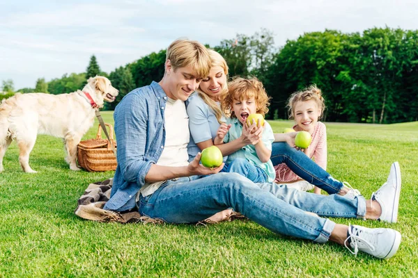 Familie som spiser epler på piknik – stockfoto