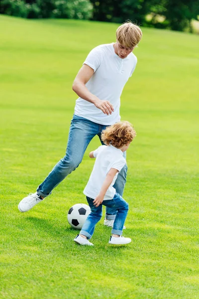 Батько і син грають у футбол у парку — стокове фото