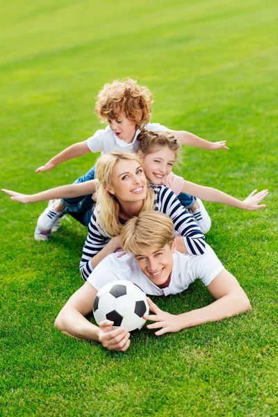 Family with soccer ball at park