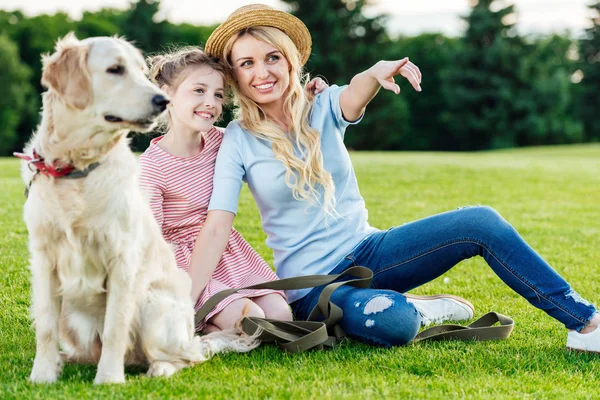 Мать и дочь с собакой в парке — стоковое фото
