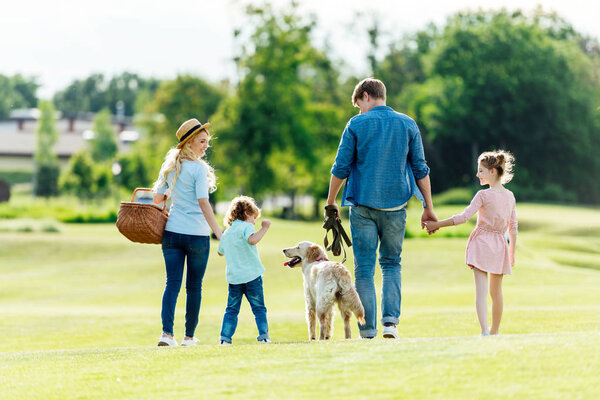 family with dog walking at park