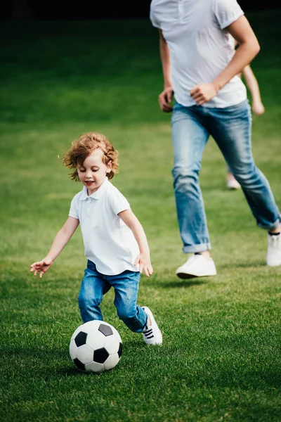 Батько і син грають у футбол у парку — стокове фото