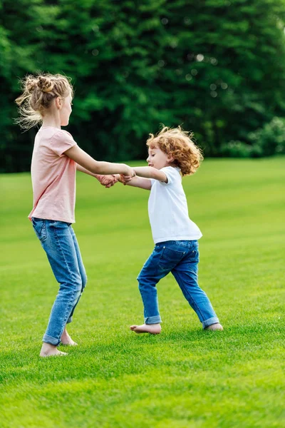 Siblings holding hands in park — Stock Photo, Image