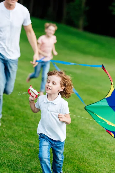 Happy family playing with kite — Stock Photo, Image