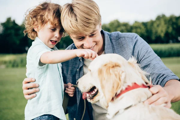 Vater und Sohn spielen mit Hund — Stockfoto