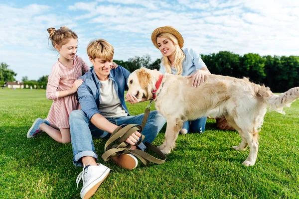 Keluarga bahagia dengan anjing di taman — Stok Foto