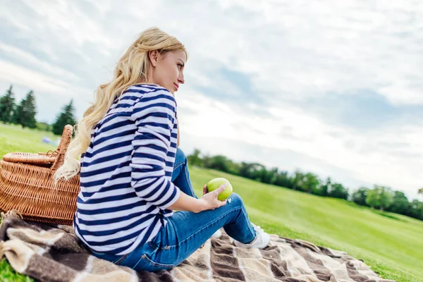 Mujer joven con manzana en el picnic — Foto de Stock