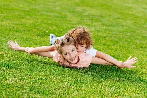 Broer en zus liggen op gras — Stockfoto