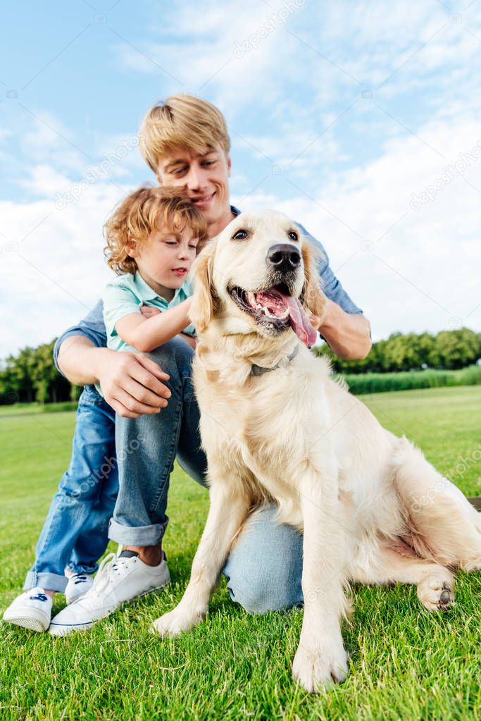 father and son with dog at park