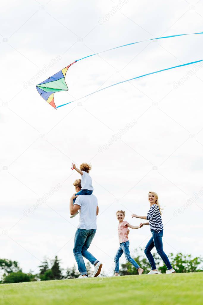 family playing with kite at park