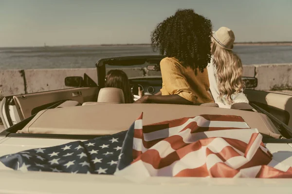 Amis assis dans une voiture avec le drapeau américain — Photo