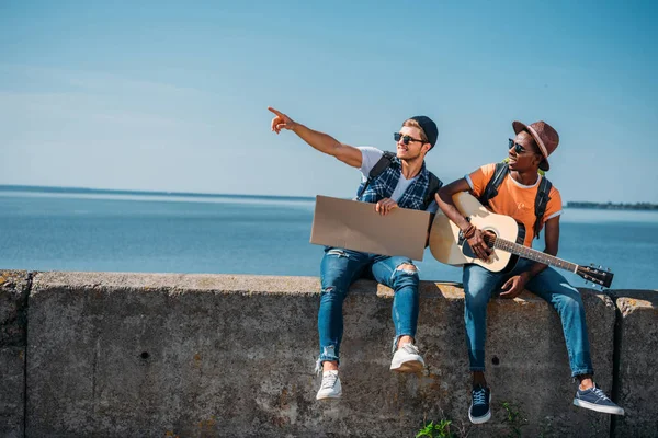 Multicultural hitchhikers with cardboard — Stock Photo, Image