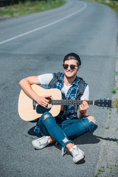 молодой человек играет на гитаре