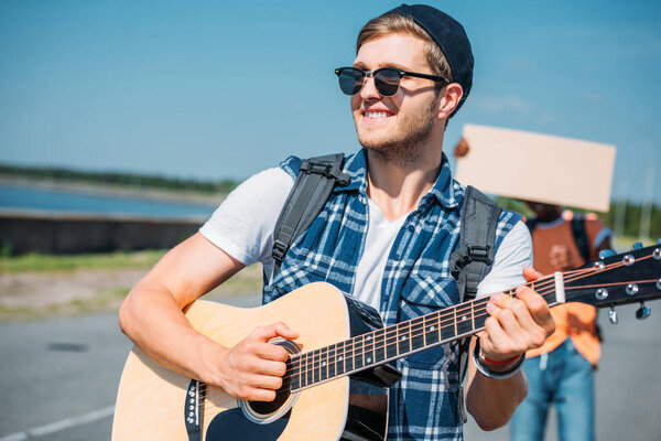 caucasian man playing guitar