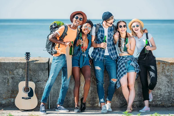 Amigos multiétnicos con botellas en las manos — Foto de Stock