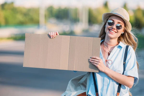 Femme souriante avec autostop en carton — Photo