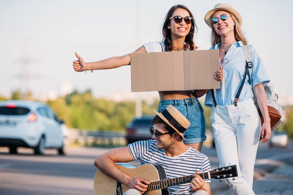 multicultural friends hitchhiking together