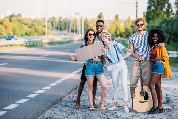 Multicultural young hitchhikers with map — Stock Photo, Image