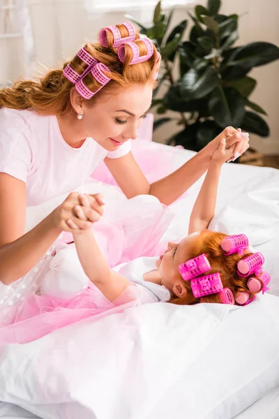 Mother and daughter lying on bed — Free Stock Photo