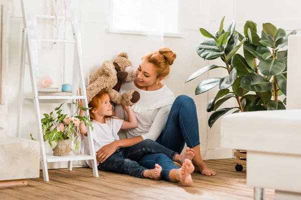 Moeder en dochter spelen met teddybeer — Stockfoto