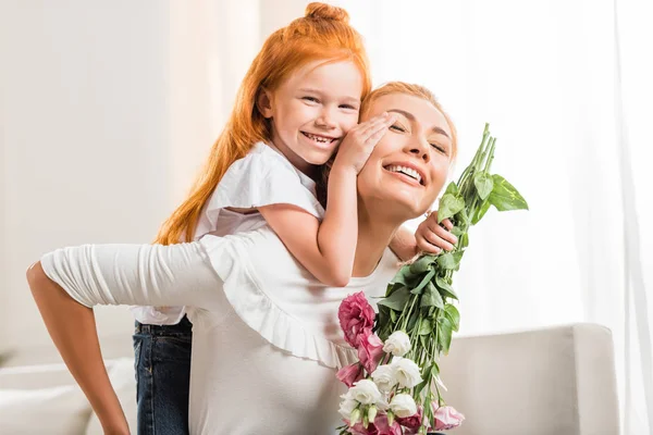 Gelukkig moeder met bloemen en dochter — Stockfoto