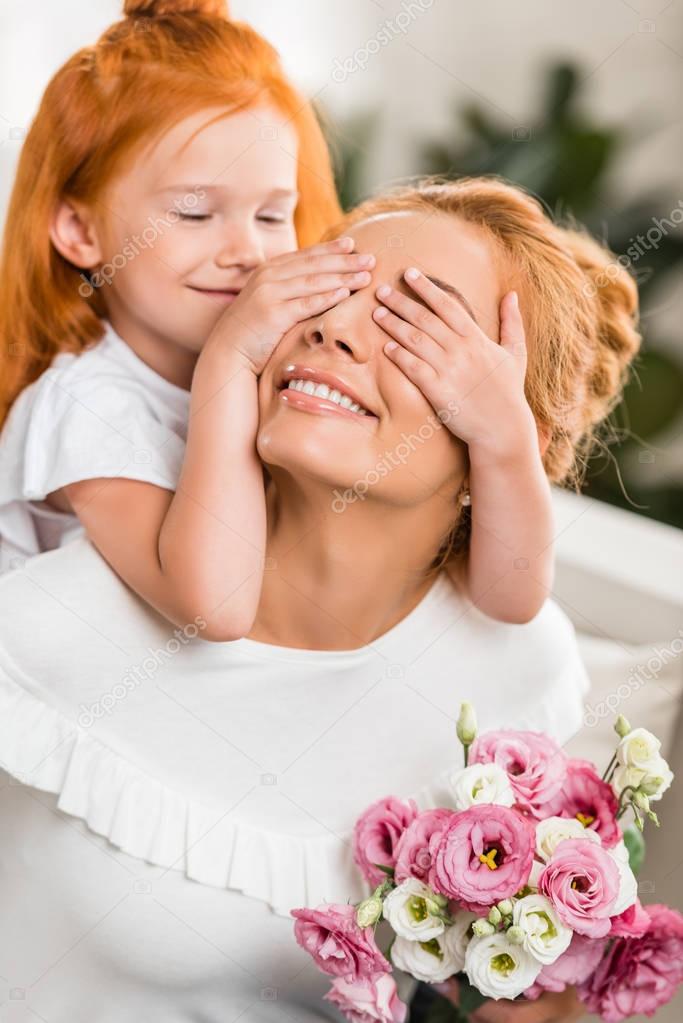 daughter covering mothers eyes